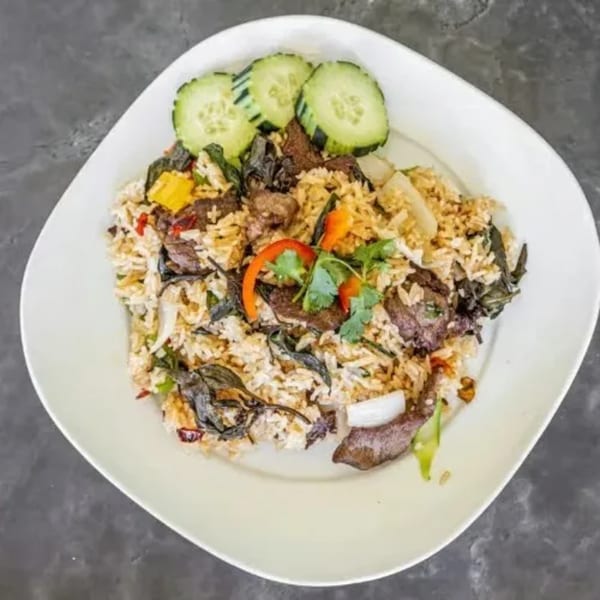 Royal Thai Orchid's Thai fried rice with beef, basil, and vegetables, garnished with cucumber slices.