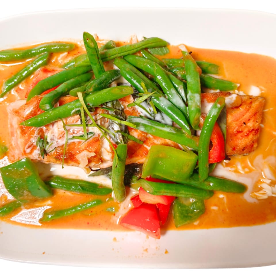 Thai red curry with salmon, green beans, and bell peppers in a creamy orange sauce.