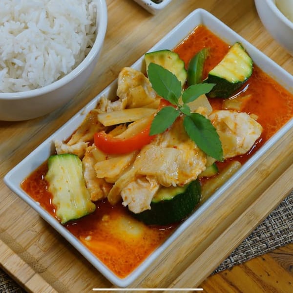 Royal Thai Orchid's red curry with chicken, zucchini, red peppers, and bamboo shoots, served with rice.